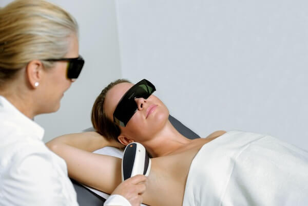 Frau wird mit Laser behandelt