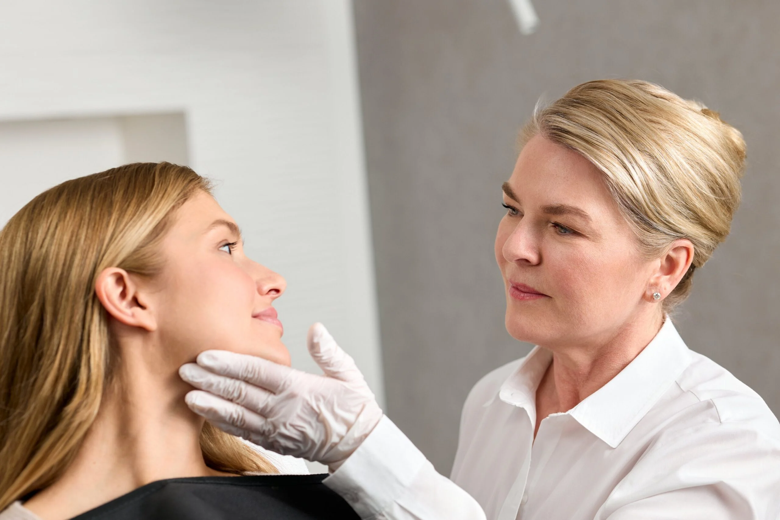 Dr. med. Daniela Wiebels tastet mit Handschuh Kinn und Wange einer Patientin ab