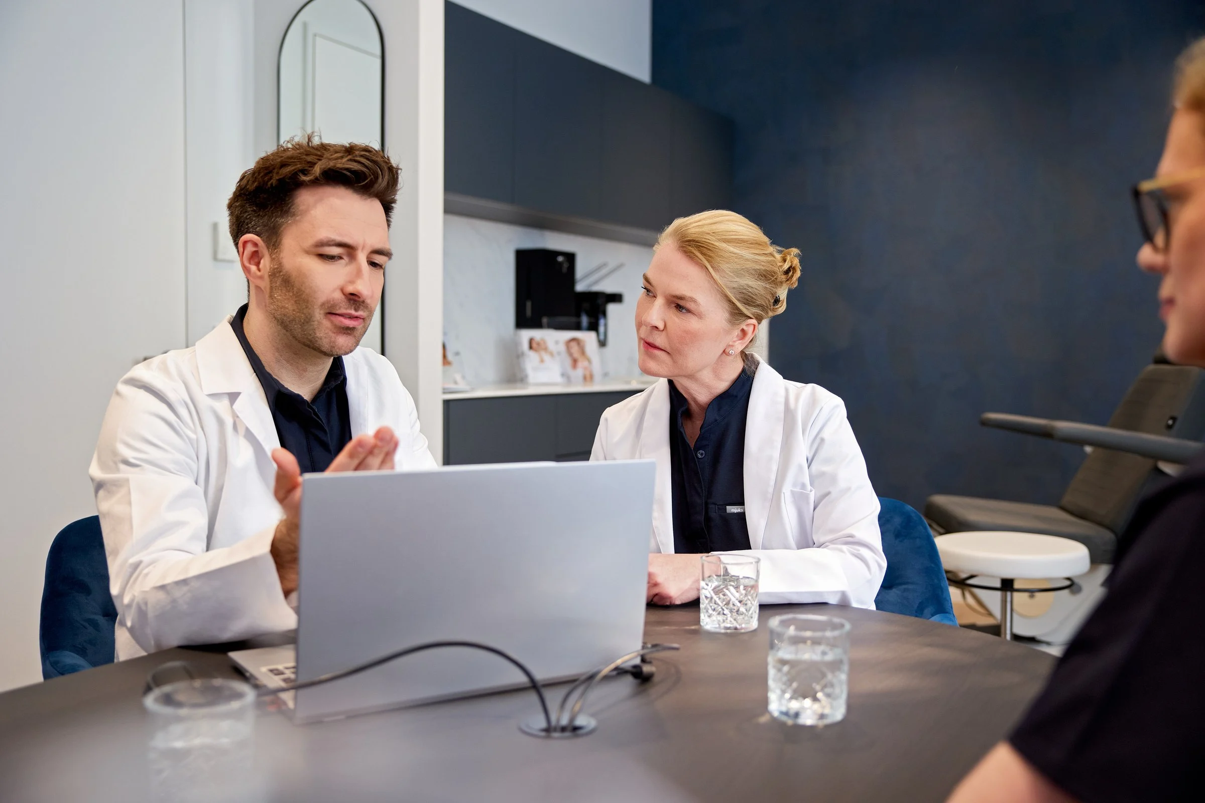 Zwei Ärzte der Hamburg Dermatologie besprechen einen Befund am Laptop